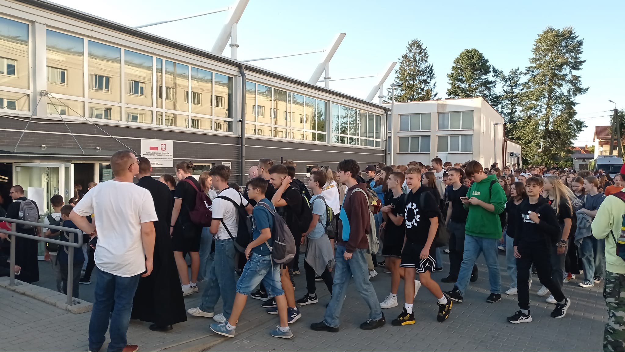 Liczna grupa młodzieży wchodzi na halę sportową Zespołu Szkół Powiatowych przy ul. Mazowieckiej w Przasnyszu