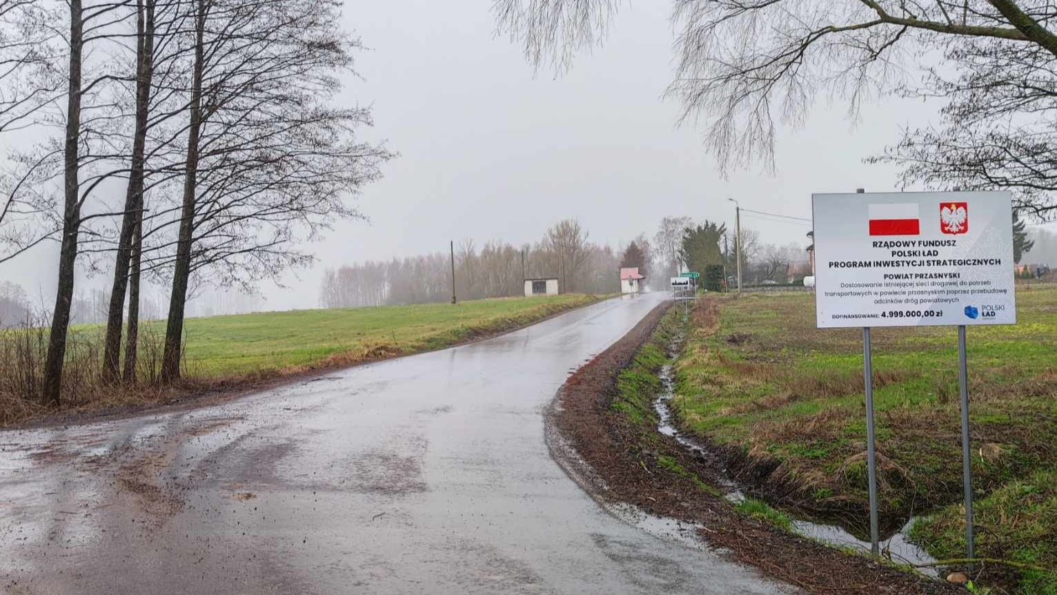 Wyremontowana droga w gminie Czernice Borowe, tablica informacyjna o dofinansowanie z Polskiego Ładu