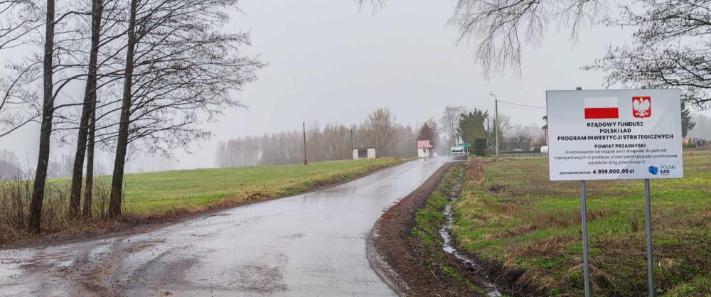 Wyremontowana droga w gminie Czernice Borowe, tablica informacyjna o dofinansowanie z Polskiego Ładu