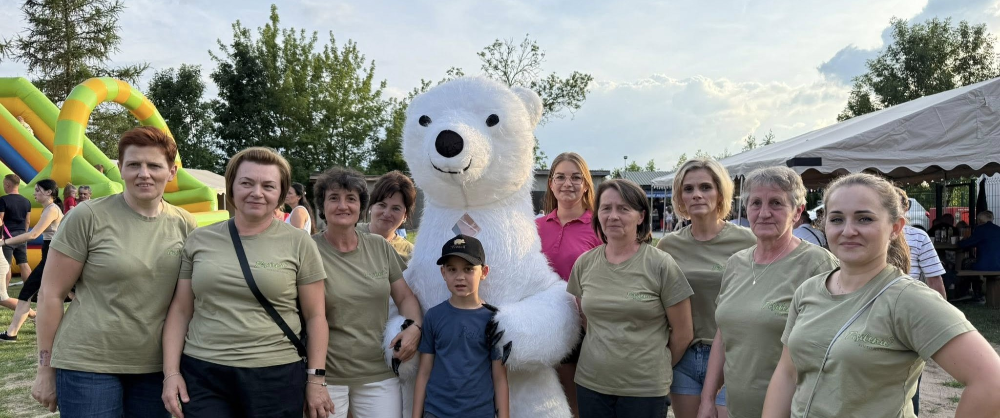 Organizatorki festynu wiejskiego Posilenie, chłopiec i duża maskotka biały miś.